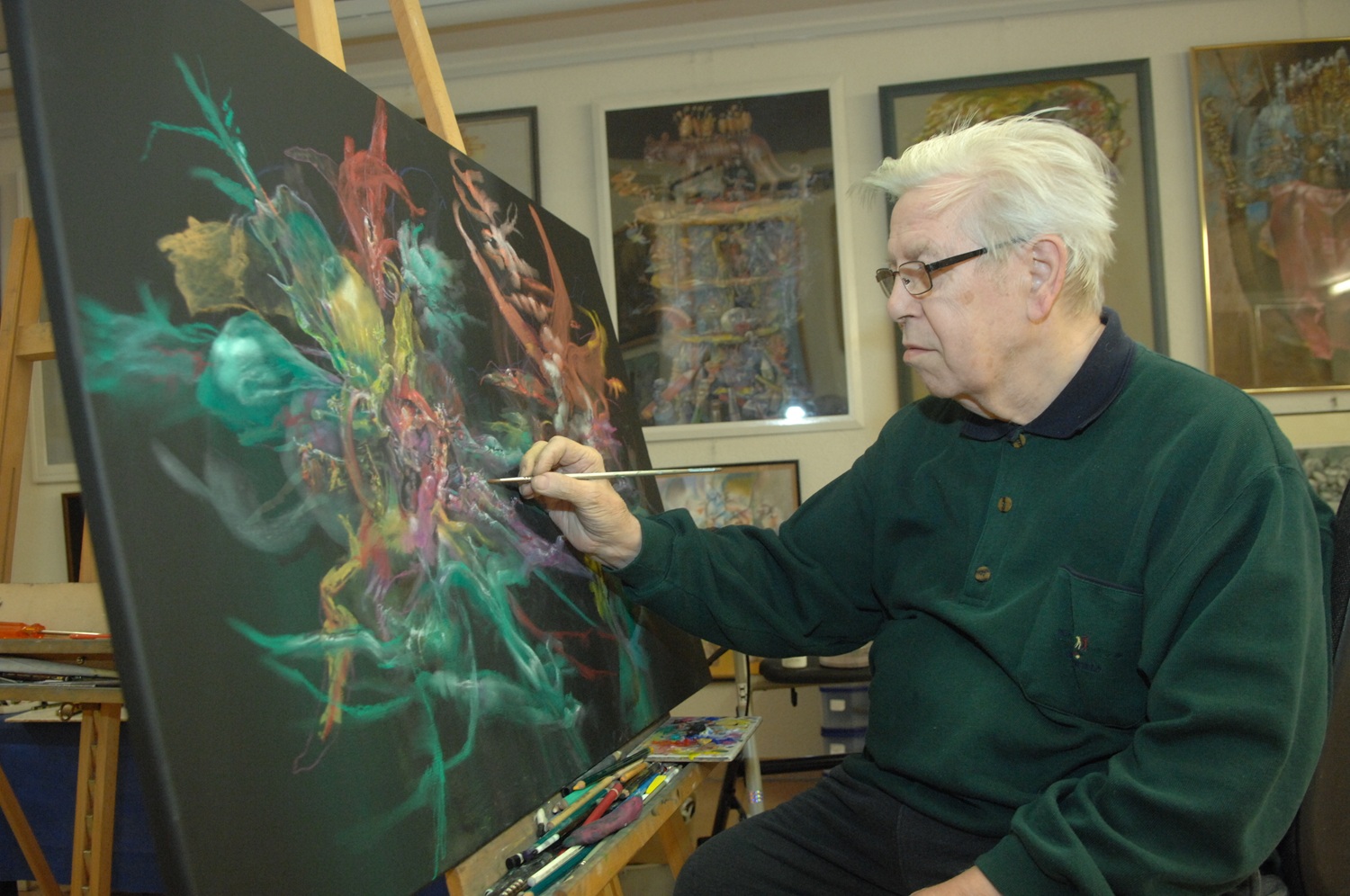 Ein Mann malt mit einem Pinsel an eine Leinwand