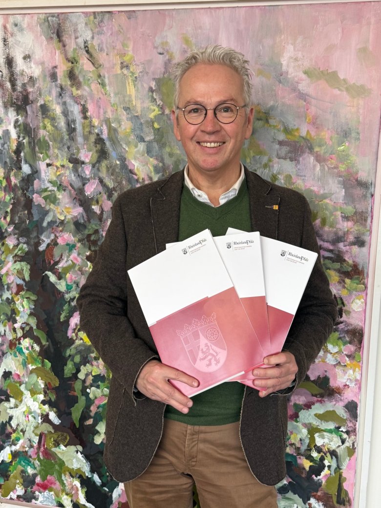 Rainer Guth mit drei Fördermittelbescheiden in Mappen Rainer Guth mit drei Fördermittelbescheiden in Mappen