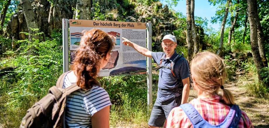 Wandergruppe an einer Informationstafel im Wald am Donnersberg Wandergruppe an einer Informationstafel im Wald am Donnersberg