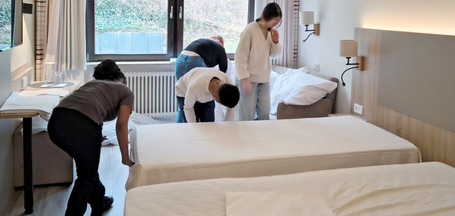 Betriebsbesuch Waldhotel Eisenberg, Schülerinnen und Schüler beim beziehen eines Bettes