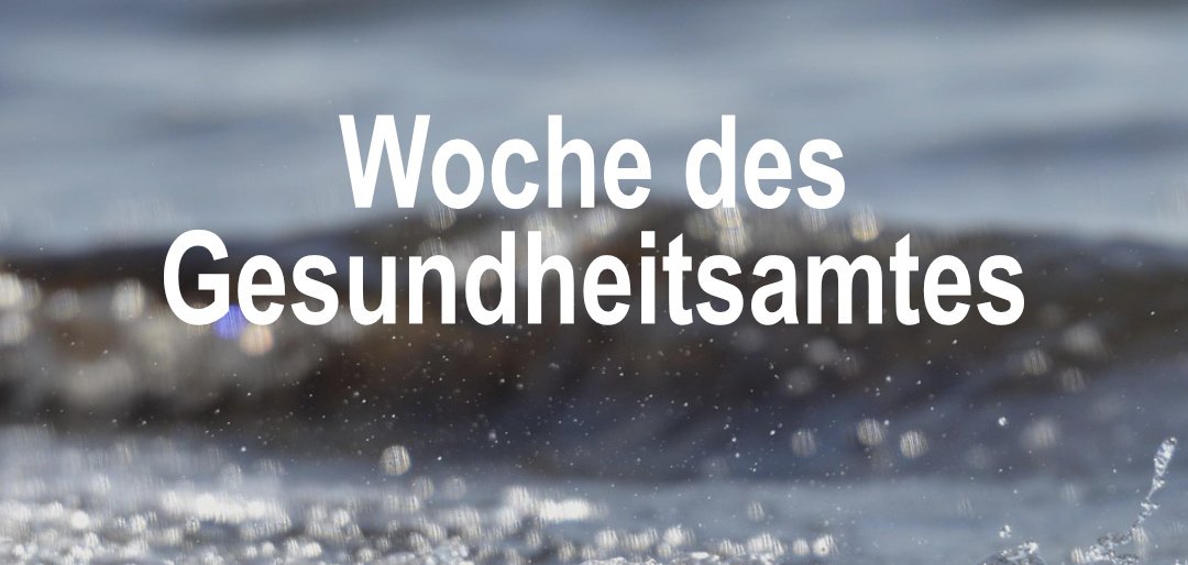Schriftzug "Woche des Gesundheitsamtes" vor Wasser am Strand