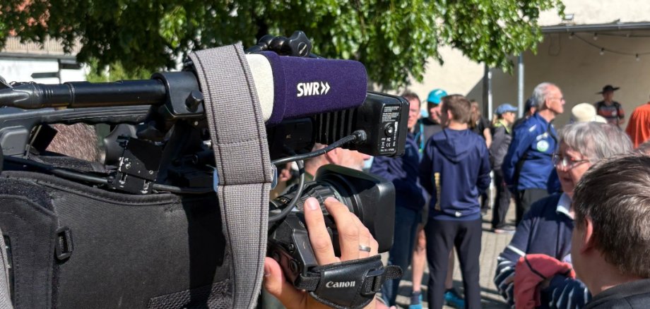 Im Vordergrund eine Fernsehkamera, dahinter Teilnehmer der Protestaktion