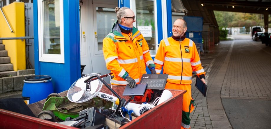 2 Mitarbeiter einer Mülldeponie mit Elektroschrott