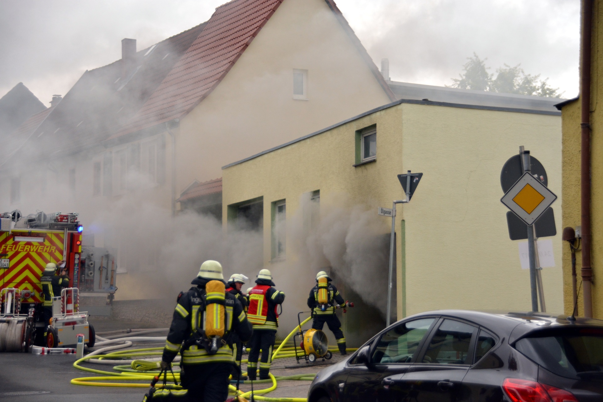 Ein brennendes Haus mit Feuerwehrleuten