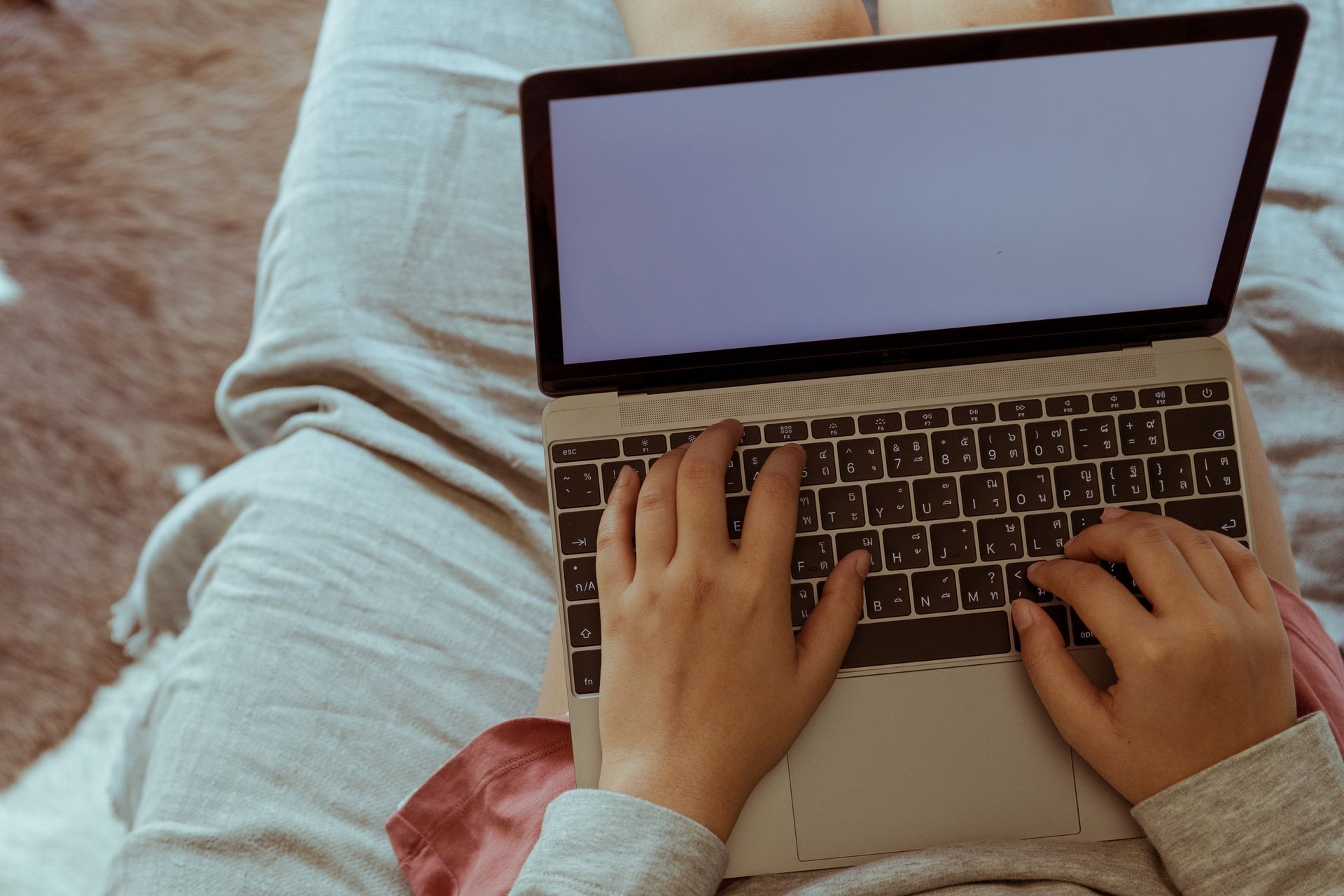 Mit Computer auf dem Sofa Blick auf einen Computer, der von einem Menschen auf dem Sofa genutzt wird