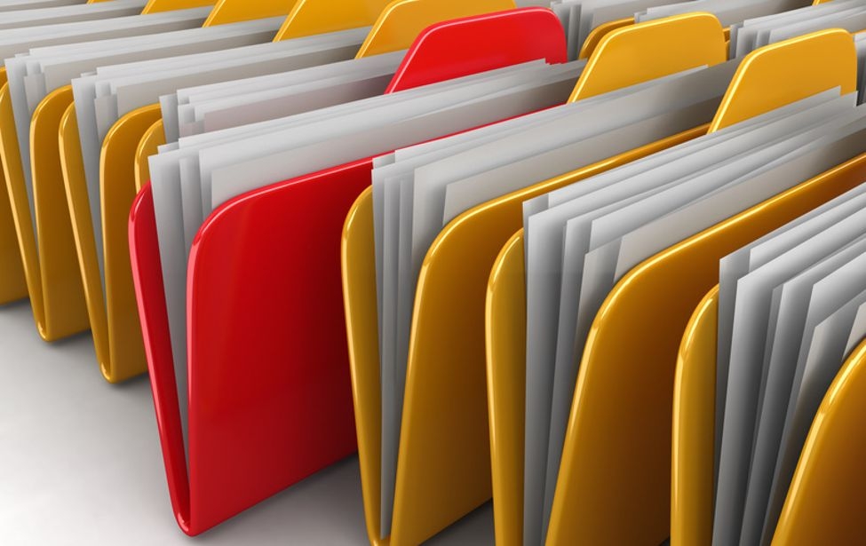 Mehrere gelbe Ordner und ein roter mit Formularen