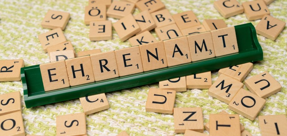 Scrabble-Buchstaben, die das Wort Ehrenamt ergeben
