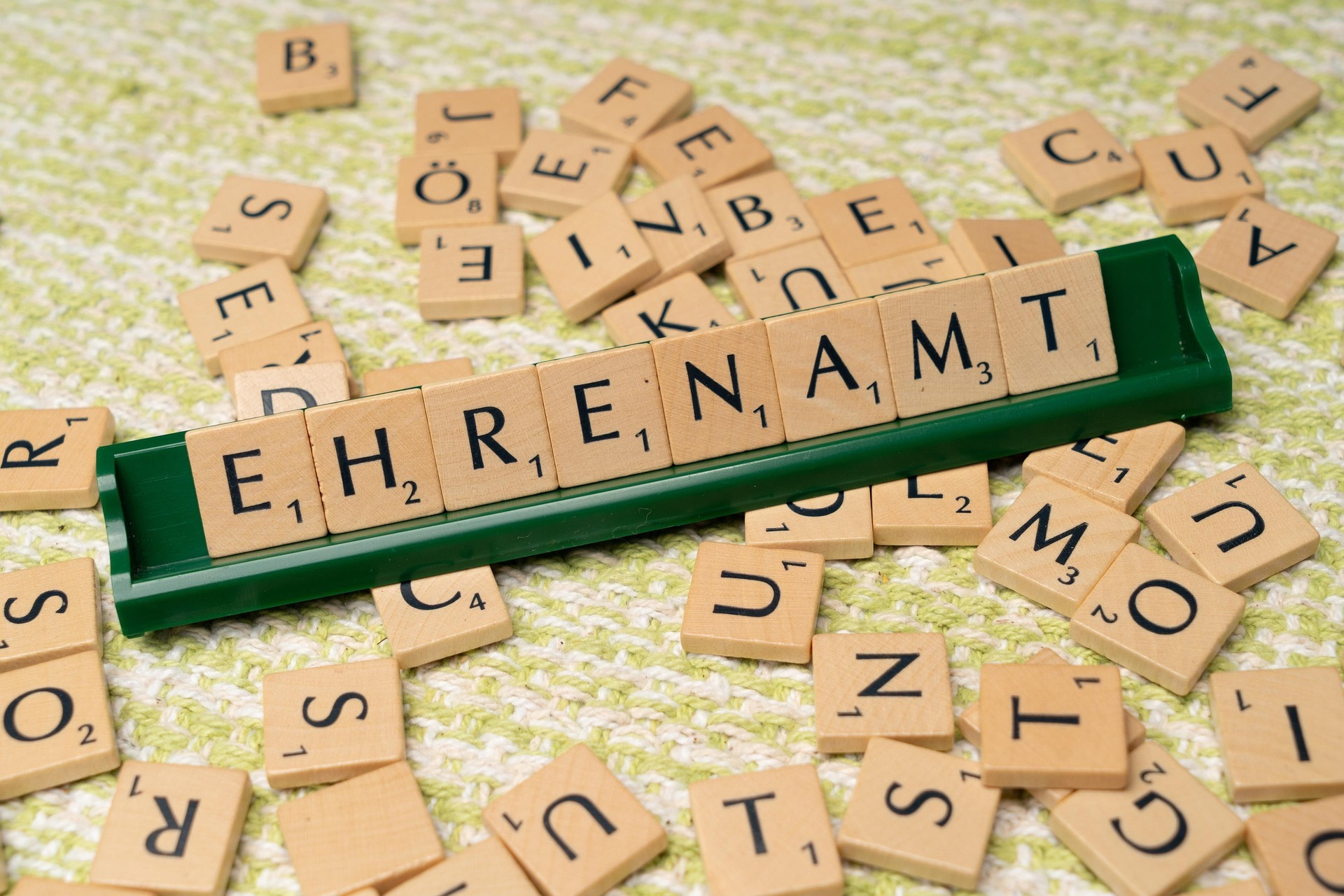 Scrabble-Buchstaben, die das Wort Ehrenamt ergeben
