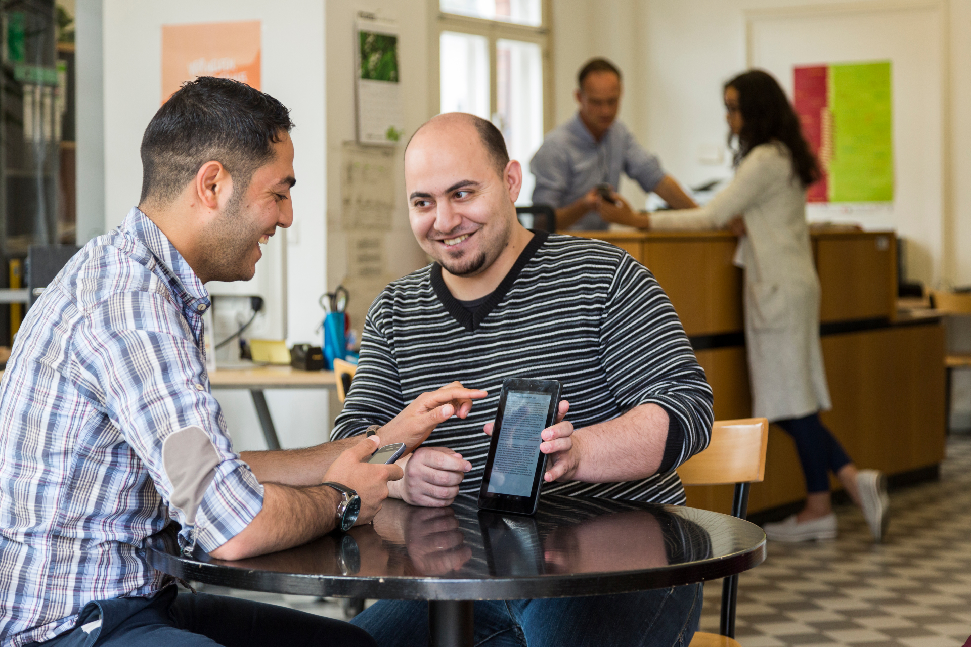 Zwei Männer an einem Tisch mit einem Tablet