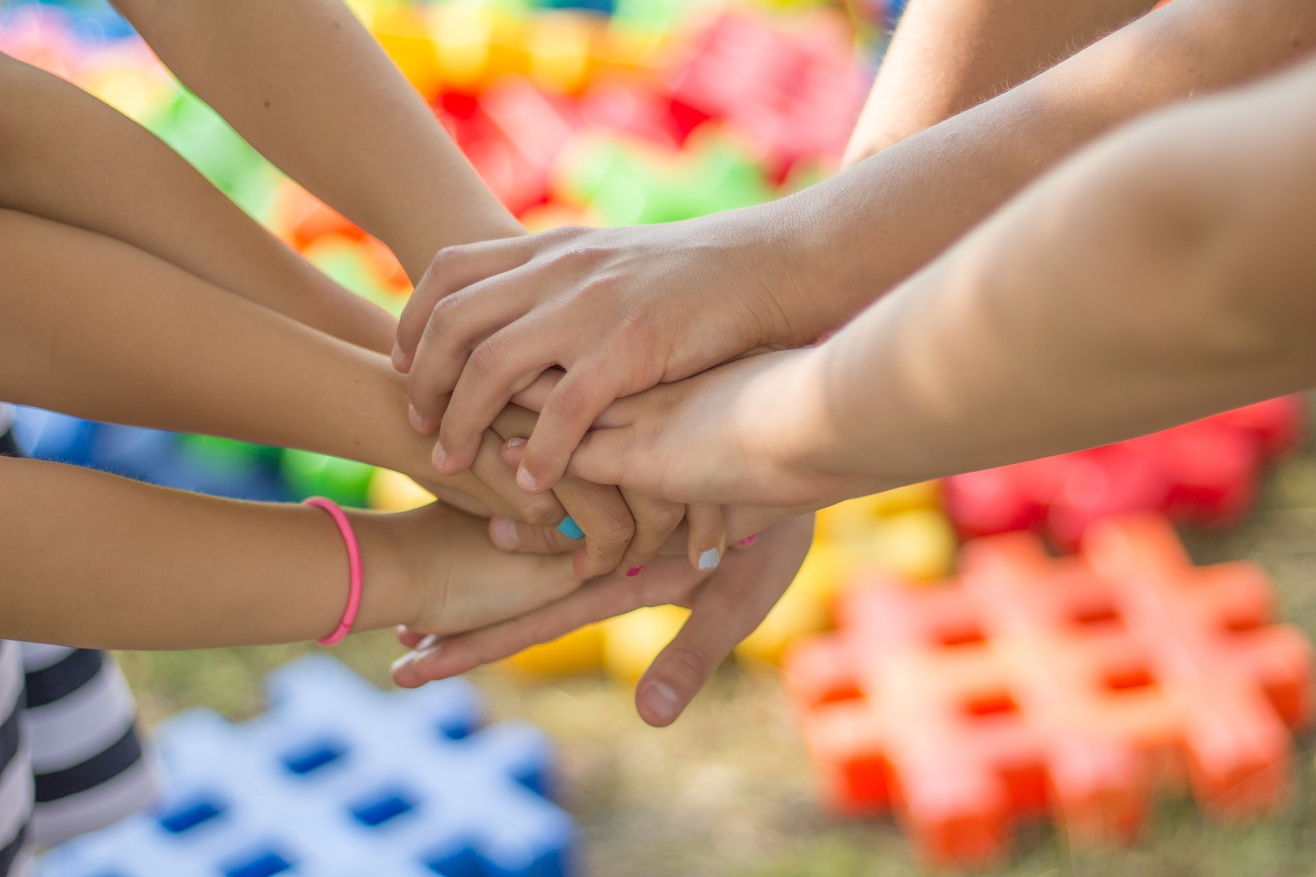 7 Hände halten sich gegenseitig fest