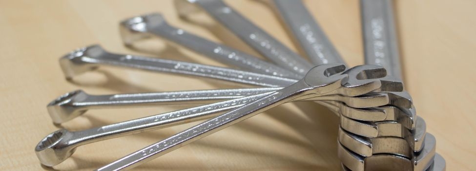 Mehrere Schraubenschlüssel, die fächerartig auf einem Tisch liegen.