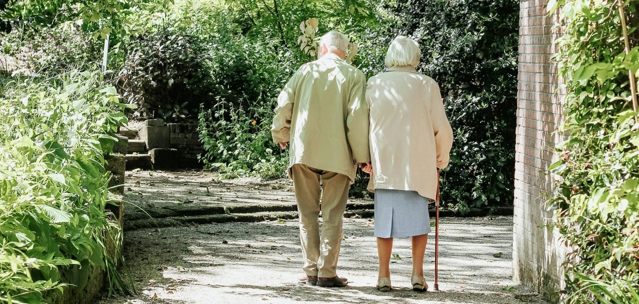 Zwei alte Menschen gehen zusammen auf einem Weg
