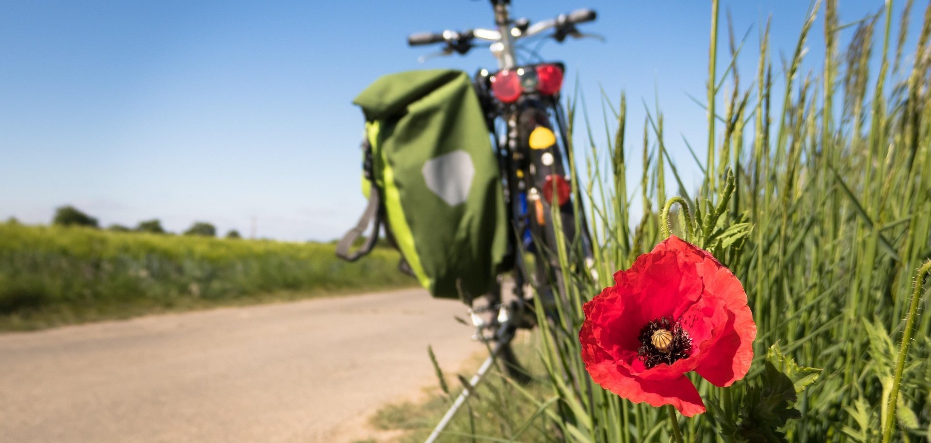 Fahrrad am Wegrand Ein Radweg im Frühling - rechts steht ein Fahrrad