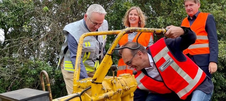 Zellertalbahn Landrat Rainer Guth und weitere Akteure sehen sich einen gelben Motor an.