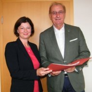 Staatssekretärin Nicole Steingaß übergibt dem 1. Beigeordneten des Donnersbergkreises, Wolfgang Erfurt, den vorläufigen Förderbescheid.