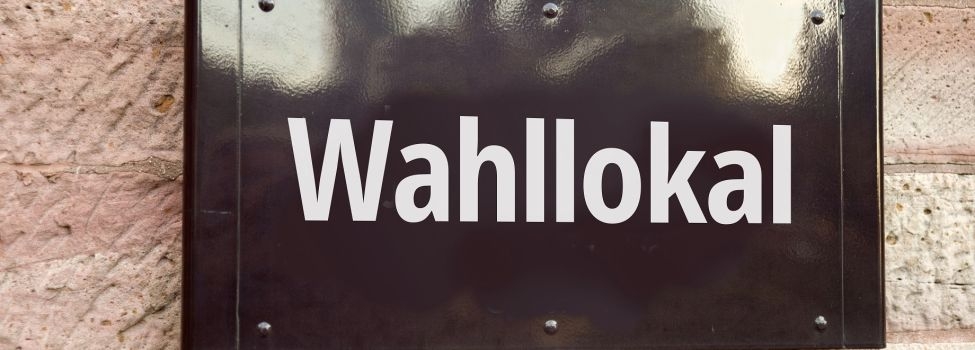 Nahaufnahme eines Schildes an einer Wand mit der Aufschrift "Wahllokal"